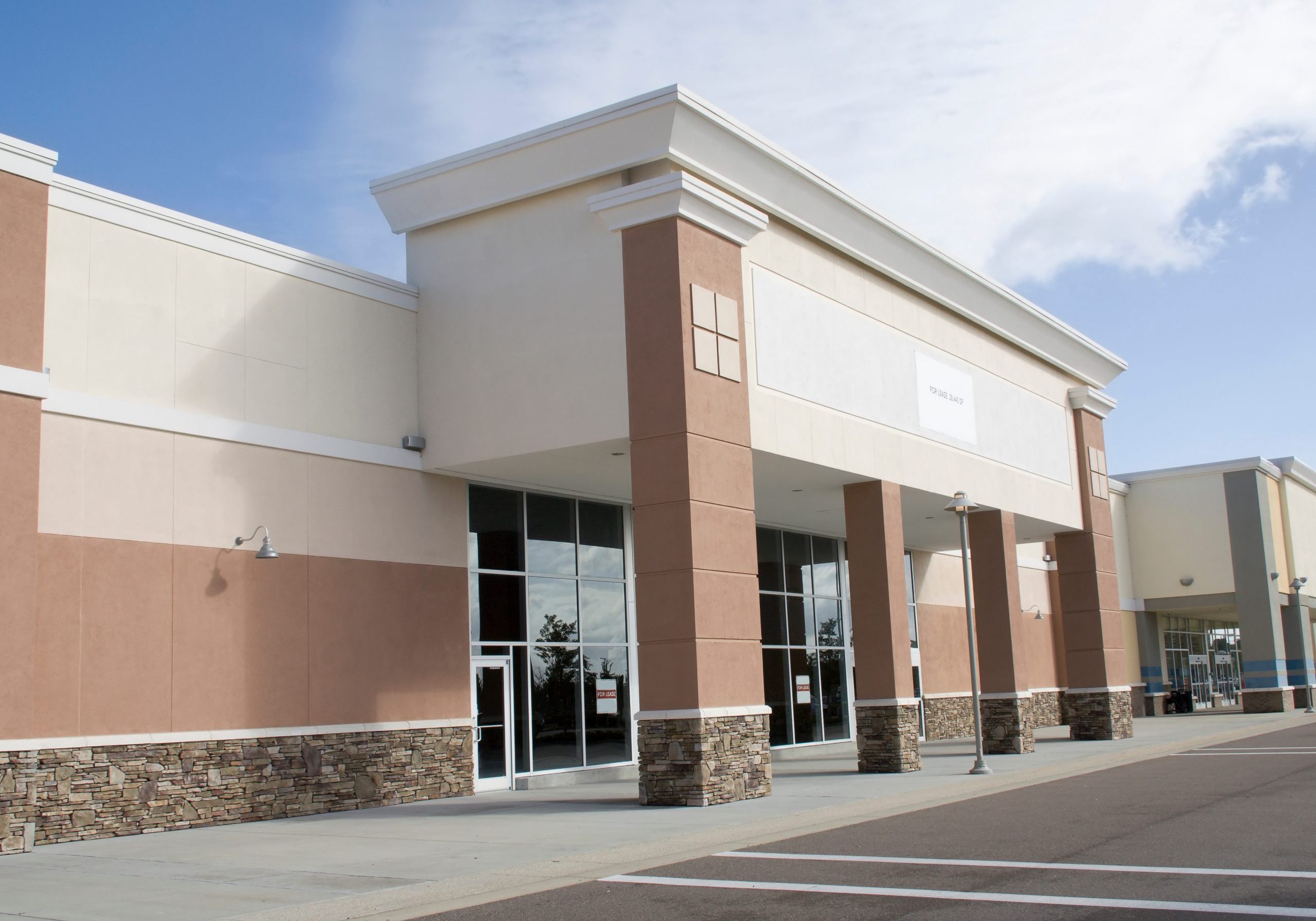 large empty retail store as part of a pastel commercial strip mall